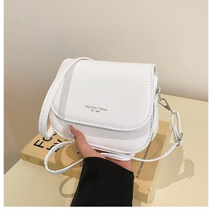 Close-up of white leather crossbody bag with Fashion Trend text on the flap cover