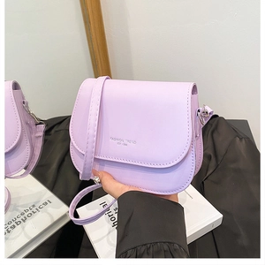 Detailed shot of lavender purple saddle bag with adjustable strap and fashion lettering