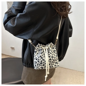 Leopard print bucket bag with drawstring closure shown on model for size and style