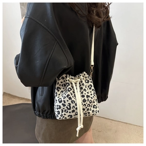 Detail shot of leopard print bucket bag with drawstring closure and crossbody strap