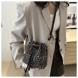 Close-up of leopard print bucket bag with drawstring closure and golden hardware detail