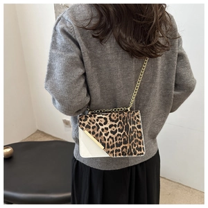 Detail of trendy leopard print shoulder bag with gold chain strap and metal trim