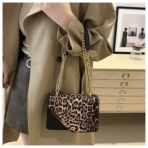 Detailed close-up of leopard print crossbody bag with gold chain and black leather trim