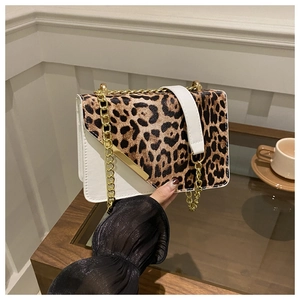 Detail of leopard print patchwork crossbody bag with golden chain and metal trim