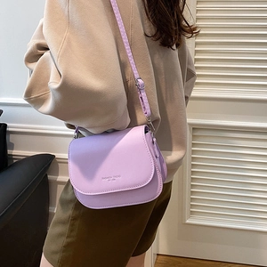 Chic purple faux leather saddle bag for women featuring an adjustable crossbody strap