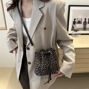Leopard print bucket bag with drawstring closure worn by model in casual style