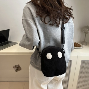 Borsa a tracolla minimalista in velluto a coste nero con dettagli rotondi su modella