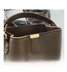 Macro di una borsa a secchiello in pelle marrone scuro con fibbia in metallo dorato