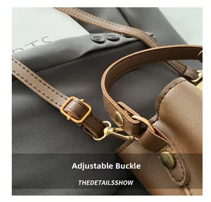 Dettaglio della fibbia regolabile e hardware metallico dorato di una borsa a secchiello