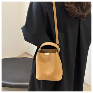 Detailansicht der khakifarbenen Beuteltasche mit Fashion-Text und verstellbarem Riemen