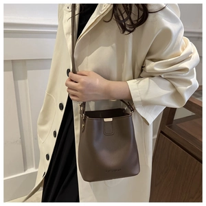 Detail einer dunkelbraunen Retro-Beuteltasche mit FASHION-Prägung auf mattem Leder-Finish