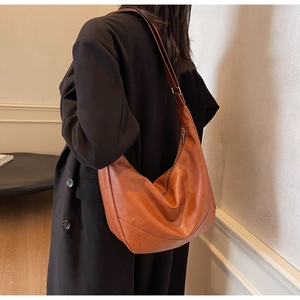 Detailed view of large brown hobo bag with soft leather texture and minimalist design