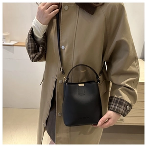 Nahaufnahme einer schwarzen Eimertasche aus Leder mit FASHION-Schriftzug und Golddetails