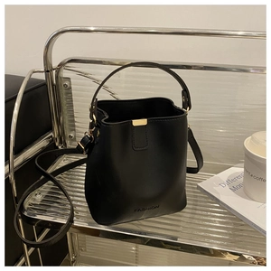Detailansicht der schwarzen matten Beuteltasche mit Goldschnalle und FASHION-Prägung