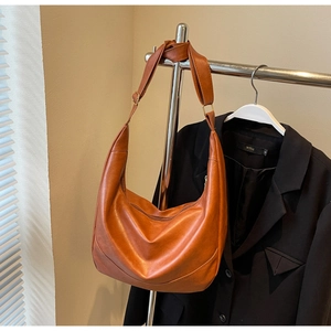 Detail of amber caramel hobo bag featuring premium matte texture and adjustable wide strap