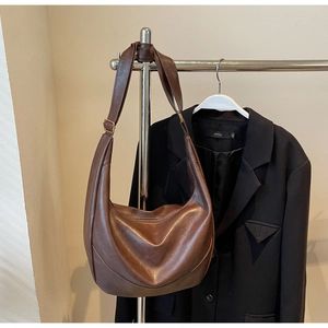 Close-up of brown vintage Hobo bag with natural leather texture and adjustable buckle