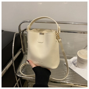 Detail der weißen Beuteltasche mit FASHION-Prägung und schmalem Schulterriemen