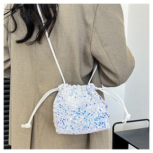 Détail de paillettes irisées scintillantes sur un sac seau à cordon tendance