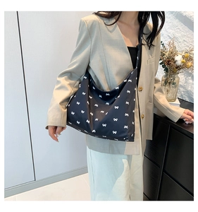 Asian model wearing a black nylon hobo bag with white bow patterns for casual style