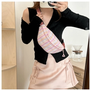 Détail d'un sac bandoulière rayé coloré avec sangle rose et tirette de fermeture
