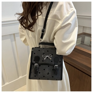 Detail einer Retro-Pünktchen-Handtasche mit silberner Schleife und doppelten Schnallen