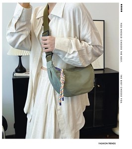 Detail of olive green nylon crescent crossbody bag with decorative woven cord