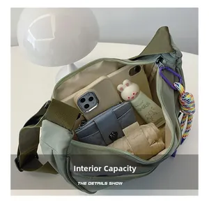 Olive green crossbody bag showing large internal capacity with umbrella and phone