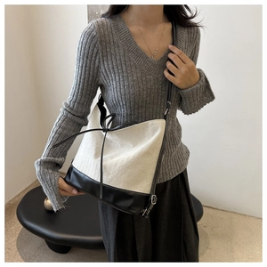 Detail shot of canvas tote featuring herringbone texture and black leather trim