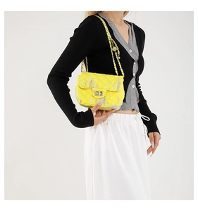 Model showing a bright yellow quilted crossbody bag with golden chain and turn-lock