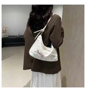 White crescent tote with colorful embroidery and ribbon bows on shoulder strap