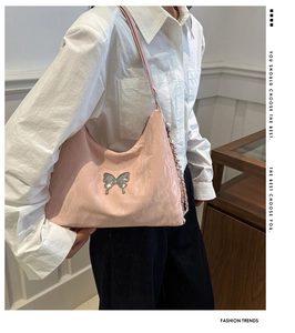 Detail of pink nylon hobo bag with silver butterfly emblem and metal chain strap