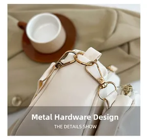 Detailed close-up of premium light gold hardware and connector on a beige leather handbag