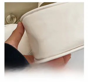 Detailed macro view showing the precise stitching and matte leather texture of the white bag