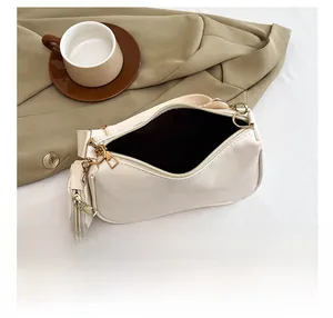 Detail show of the spacious cream PU leather shoulder bag with gold hardware and coin purse