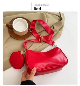 Detail view of red crescent bag with wide fabric strap and matching mini coin purse