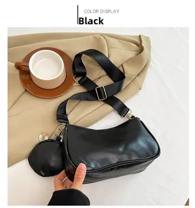 Detail of black crossbody bag with wide strap and round coin purse attachment