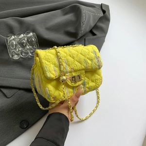 Stylish yellow quilted crossbody bag with gold chain strap and textured fabric embroidery