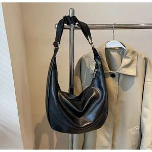Detail shot of black leather hobo bag with a gold metal zipper and soft textures