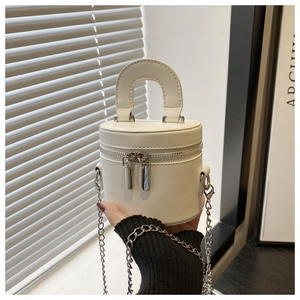 Detail of white leather mini bucket bag with silver chain and dual zipper closure