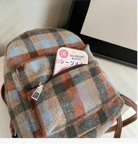 Close-up of British style plaid wool backpack with silver zipper pocket detail