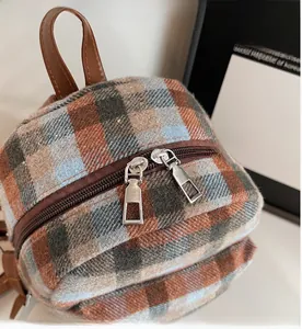 Detail view of the smooth dual zipper closure on a vintage plaid wool mini backpack