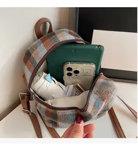 Detailed view of plaid wool backpack interior showing capacity for tablets and umbrellas
