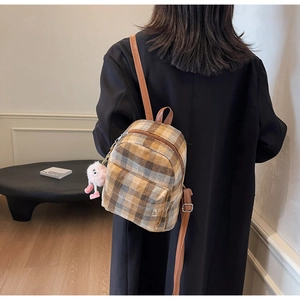 Detailansicht Mini-Rucksack mit Karomuster, Lederriemen und rosa Plüsch-Anhänger