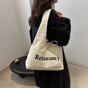Cream canvas tote bag with Rebawancy print and decorative side bow for women