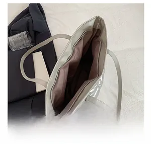 Detail view of silver quilted tote bag showing interior lining and smooth zipper closure