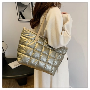 Detail of champagne gold quilted tote bag with elegant rhombus pattern and leather strap