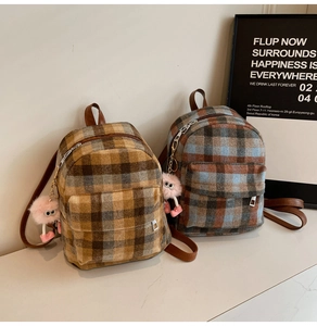 Detail of mini tweed checkered backpacks with plush pendants and leather straps