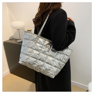 Sac fourre-tout argenté matelassé en tissu bouffant métallique porté par un mannequin