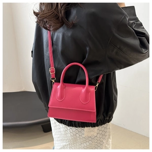 Fuchsia square handbag detail showing styling with black leather jacket and white dress