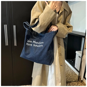 Detail of navy denim tote bag with Less Mondays More Sundays print and shoulder strap
